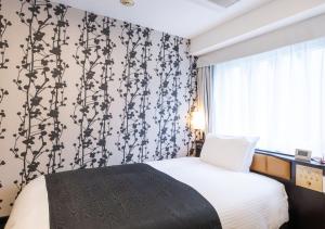 a bedroom with a bed with a black and white patterned wall at APA Hotel Kyoto Eki Horikawadori in Kyoto