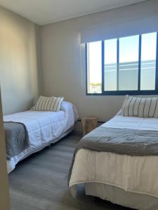 two beds in a room with two windows at Casa Cibelli in Rufino