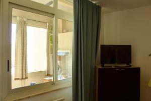 a living room with a window and a television at Casa Arcobaleno in Marsala