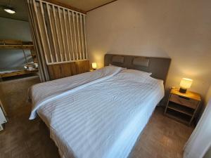 a bedroom with a large white bed and a window at Sandmo Holiday Home 11 in Eckerö