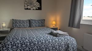 a bedroom with a bed with a blue and white comforter at NG Property in Glasgow