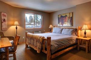 a bedroom with a bed and a table and two lamps at River Pines Inn in Winthrop