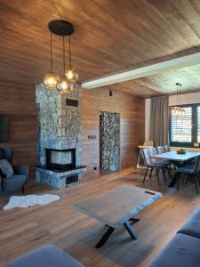 a living room with a stone fireplace and a table at Chalet Johannes in Liptovský Ján