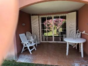 a patio with chairs and a table and a window at le dramont in Saint-Raphaël
