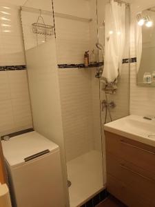 a white bathroom with a shower and a sink at le dramont in Saint-Raphaël