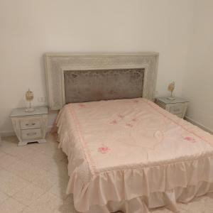a bedroom with a large bed with two night stands at Location Kelibia in Kelibia