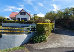 a fence in front of a house with bushes at Ilodays in La Plaine des Cafres
