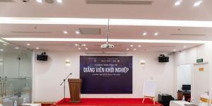 a stage with a podium in front of a screen at A25 Premium Hotel - 16 Miếu Đầm in Hanoi