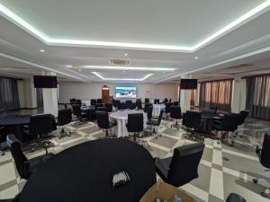 a conference room with tables and chairs and a projection screen at Kampala Nile Resort in Seeta
