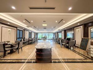 a restaurant with tables and chairs and a chalkboard at A25 Premium Hotel - 16 Miếu Đầm in Hanoi