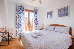 a bedroom with a bed and a chair and a window at Bungalow Barlovento Playa in Arenales del Sol +30 photos