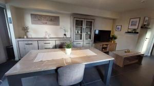 a dining room table with two chairs and a television at B&B 't Meesterhof in Deinze