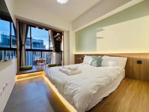 a bedroom with a large bed and a large window at mini嵐輕旅 in Guanyin