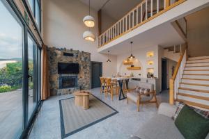 a living room with a fireplace and a table with chairs at Nish Vadi Villas in Sapanca