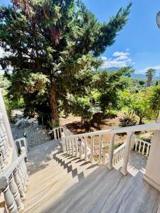 a wooden staircase leading to a deck with a tree at Villa w Studio, Pool, Garden, Sleeps 12 to 15 in Rákhai