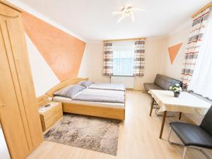 a small bedroom with a bed and a table at Feistritzer in Seeboden