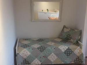 a bedroom with a bed with a quilt and a mirror at Departamentos Playa Quequen in Quequén