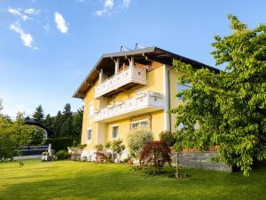 a yellow building with a balcony on a yard at Feistritzer in Seeboden