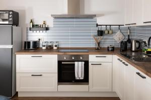 a kitchen with white cabinets and a black appliance at Lukova hiša- Luka's house in Vipava