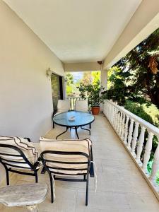 a patio with chairs and a table on a balcony at Villa w Studio, Pool, Garden, Sleeps 12 to 15 in Rákhai