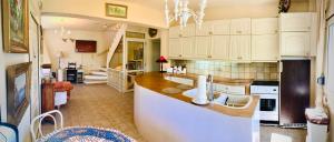 a large kitchen with white cabinets and a sink at Calm Sea House in Nea Fokea