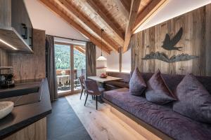 a living room with a purple couch and a table at Oberkantiolhof in Villnoss