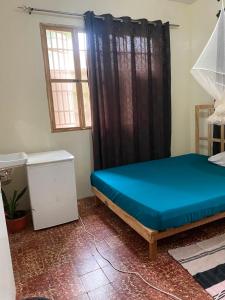 a bedroom with a blue bed and a window at Homestay in Wilkinson road in Freetown