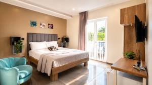 a bedroom with a bed and a chair and a window at Brahma luxury B&B in Marigliano