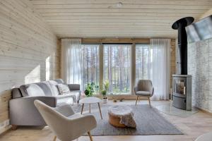 a living room with a couch and a fireplace at Villa Winter - Valkea Homes in Pyhätunturi