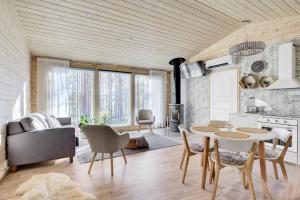 a kitchen and living room with a table and chairs at Villa Winter - Valkea Homes in Pyhätunturi