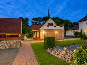 a house with a brick driveway and a church at Kalvi tee Puhkemaja in Viru-Nigula