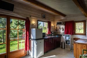 a kitchen with a white refrigerator in a room at chalet 2 personnes in Mialanes