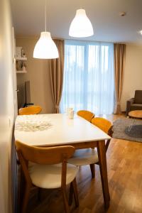 a dining room table and chairs in a living room at Naglio apartamentai Elija in Šventoji