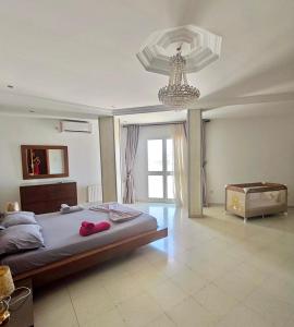 a bedroom with a large bed and a chandelier at Panoramic Seafront 350sqm Flat in Hammam Sousse