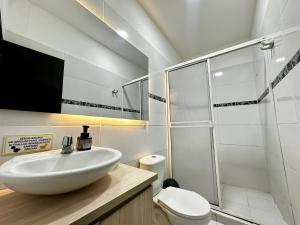a white bathroom with a sink and a shower at HOTEL HERMOSO CARIBE in Tolú