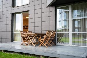 two chairs and a table on the porch of a building at Naglio apartamentai Elija in Šventoji