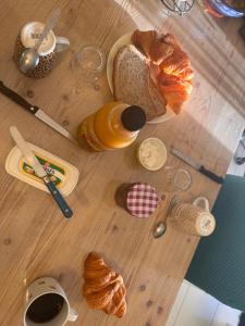 a table with bread and a cup of coffee and croissants at Chambre chez habitant résidence piscine in Carpentras