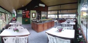 a restaurant with white tables and white chairs at Pousada Estrela do Mar in Ilha do Mel