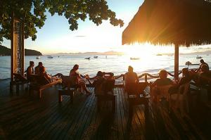 a group of people sitting at tables on the beach at Pousada Estrela do Mar in Ilha do Mel