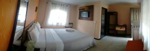 1 dormitorio con cama blanca y ventana en Pousada Estrela do Mar, en Ilha do Mel