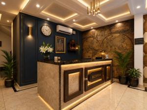 a lobby with a reception desk with a clock on the wall at Hotel Marina Premium Near IGI Airport Delhi in New Delhi