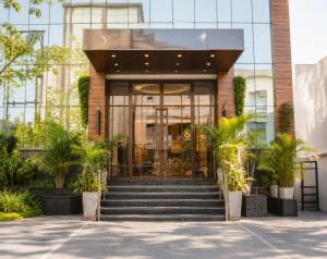 a lobby of a building with stairs and plants at The Park Central in Lucknow
