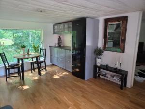 a kitchen and dining room with a table and a refrigerator at Mysigt hus på 40 kvm i Målaskog in Ryssby