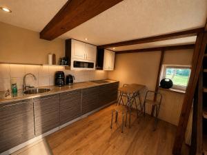 a kitchen with a sink and a counter top at Cenkones Bungalow in Cenkoņi
