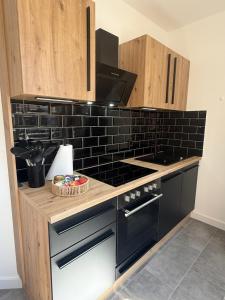 a kitchen with a counter with a stove top oven at Urban Nest Burg - Design Apartment mit Smart-TV, Self Check-in & Free Parking in Burg +2 photos