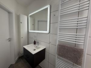 a white bathroom with a sink and a mirror at Urban Nest Burg - Design Apartment mit Smart-TV, Self Check-in & Free Parking in Burg