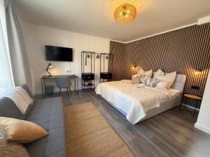 a bedroom with a bed and a desk and a television at Urban Nest Burg - Design Apartment mit Smart-TV, Self Check-in & Free Parking in Burg
