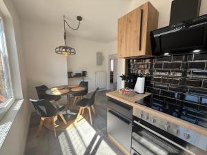 a kitchen with a table and chairs and a stove at Urban Nest Burg - Design Apartment mit Smart-TV, Self Check-in & Free Parking in Burg