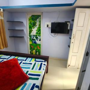 a small room with a bed and a television at SM GARDENS Nature Stay Kodaikanal in Oothu