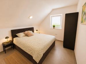 a bedroom with a bed and a window at The River House in Mavčiče